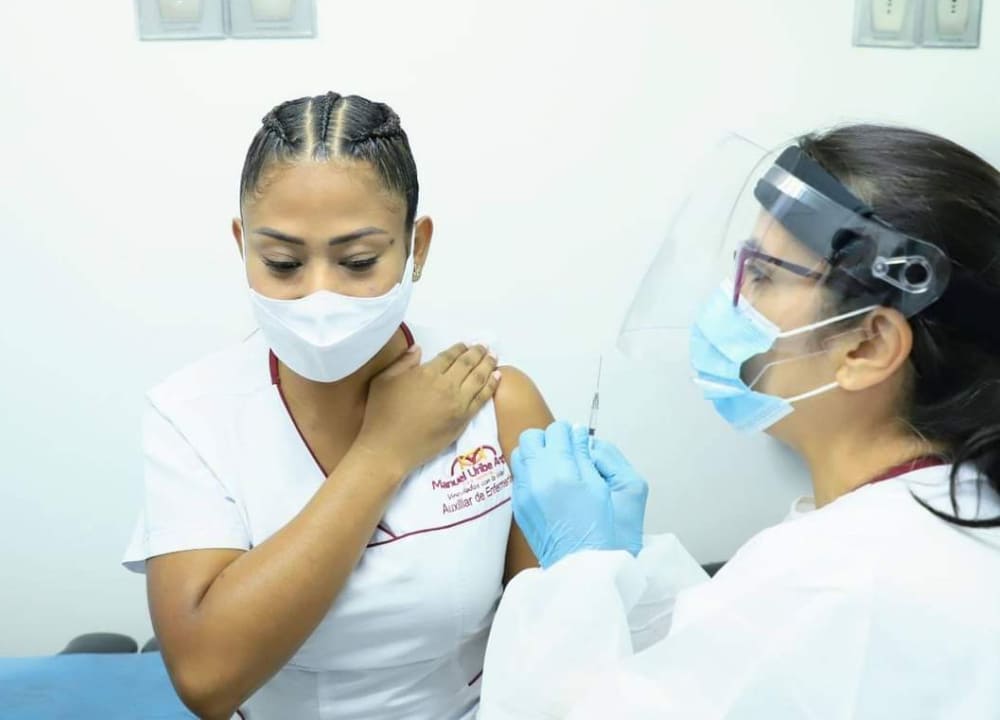 ​Andrea Díaz Hernández, Auxiliar de Enfermería UCIA, recibiendo la vacuna Pfizer contra COVID-19